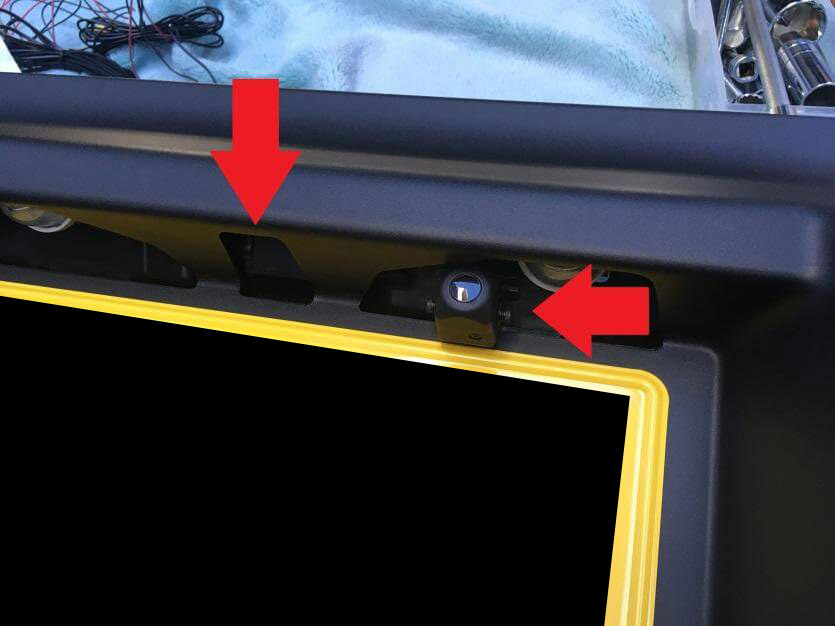 バックカメラ用の穴（下矢印）ずらして取りつけたカメラ（左矢印）